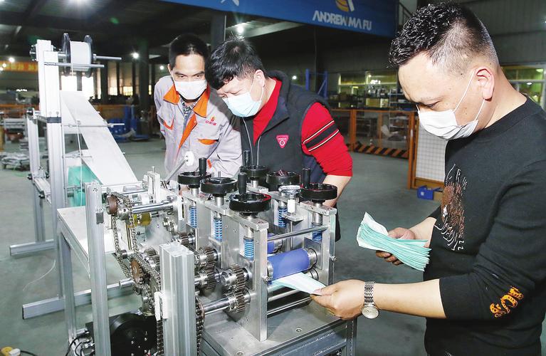 在龙海市安得马富机械生产车间,技术人员正在对新研发的口罩